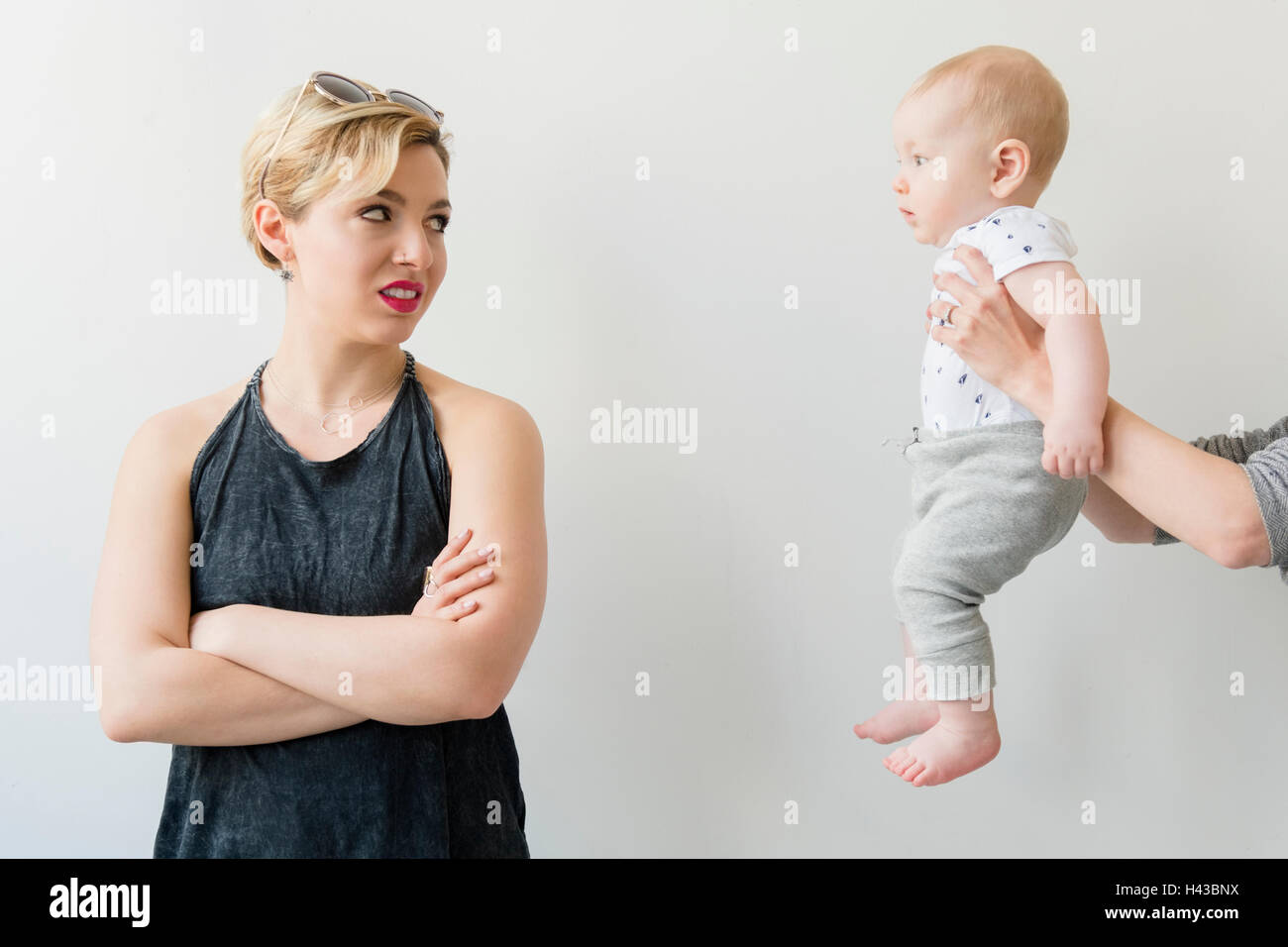 Caucasian woman disgusted at woman offering baby Stock Photo