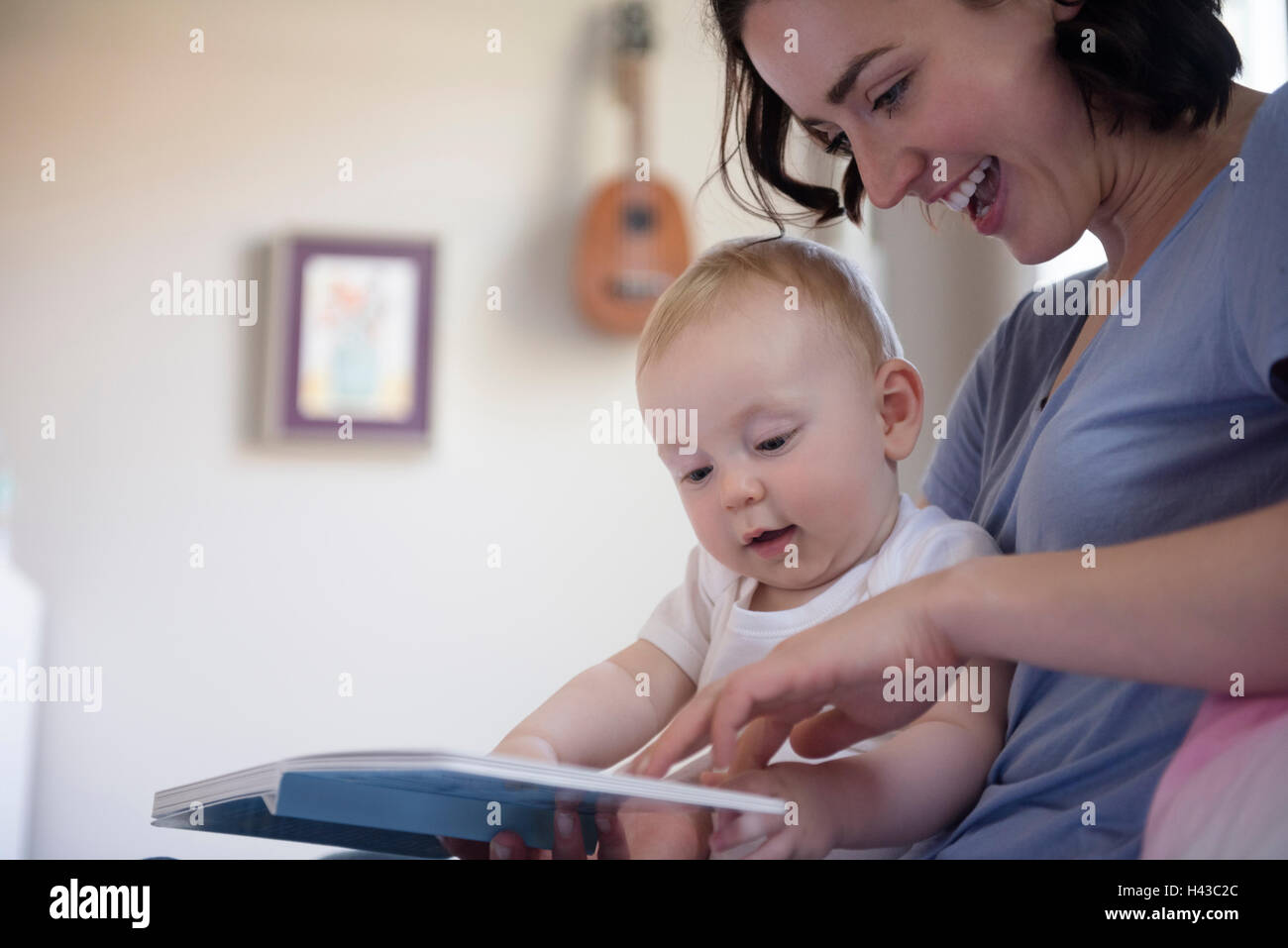 Caucasian mother reading book to baby son Stock Photo