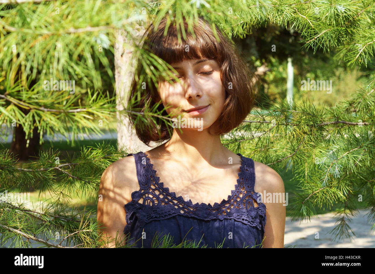 Portrait of a woman in park with her eyes closed Stock Photo - Alamy