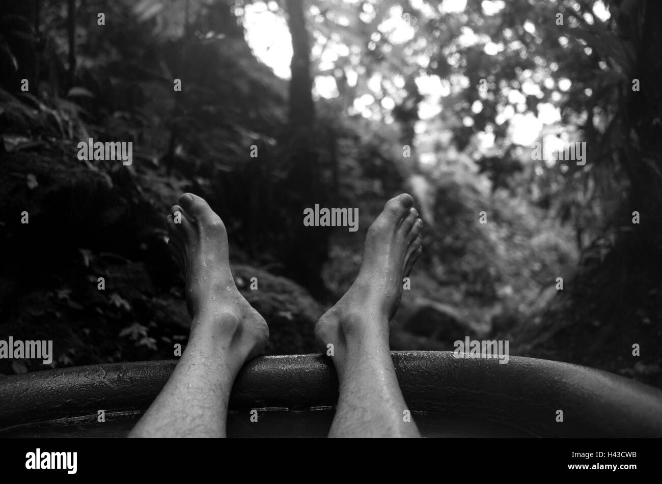 Feet of man soaking in tub outdoors Stock Photo