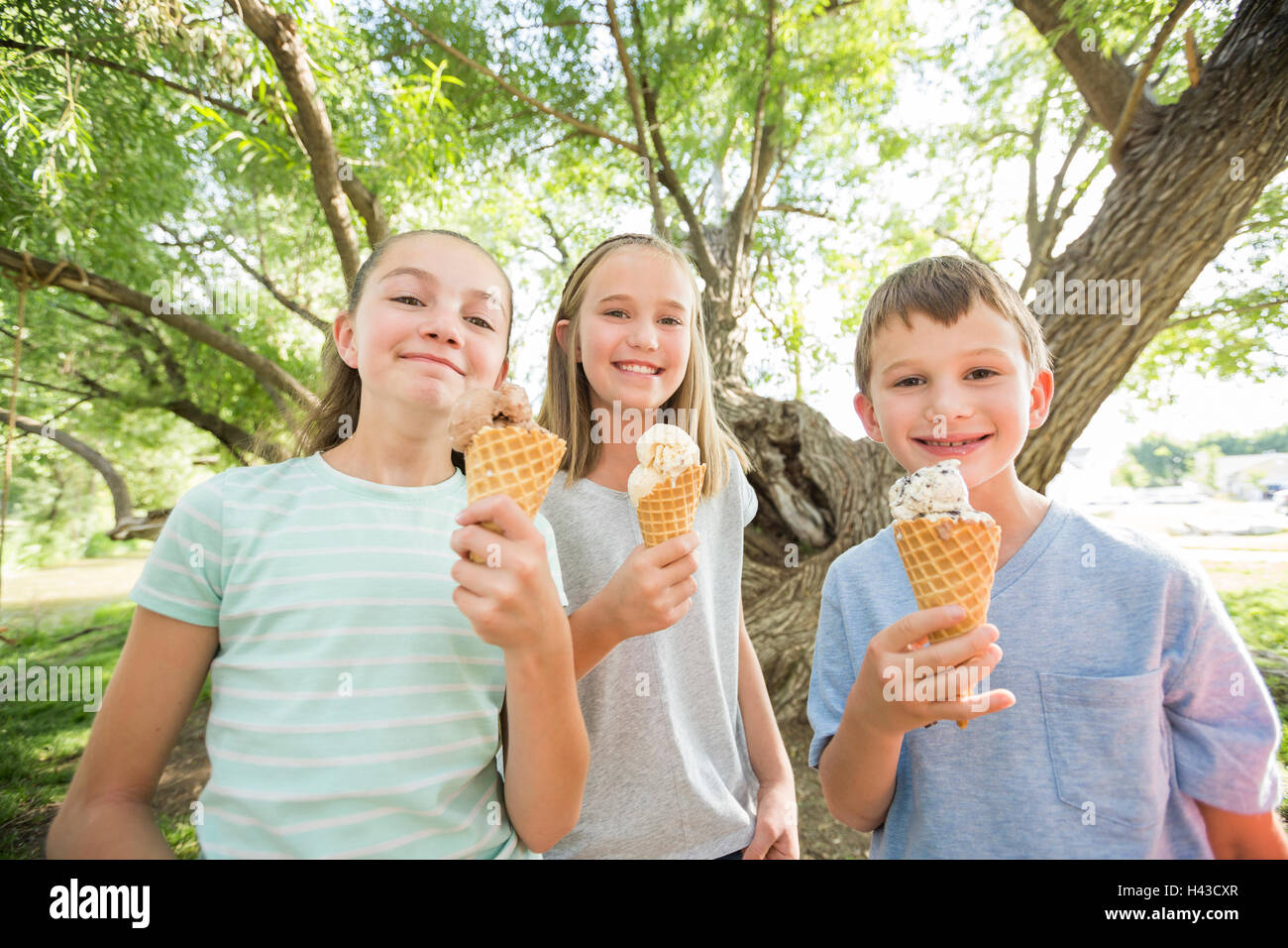 Caucasian boy and girls eating ice cream cones Stock Photo