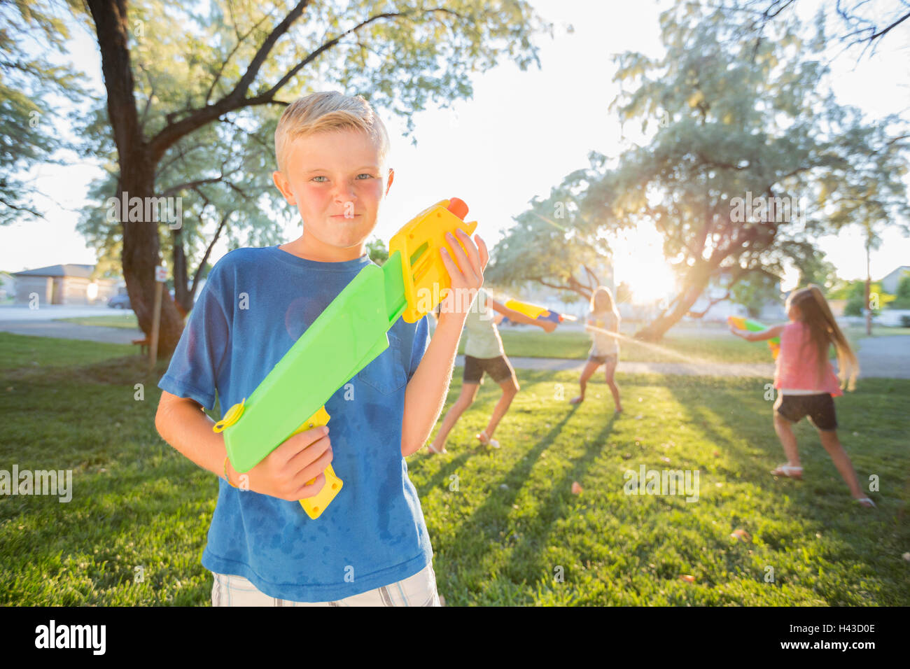 Caucasian boy posing with squirt guns Stock Photo
