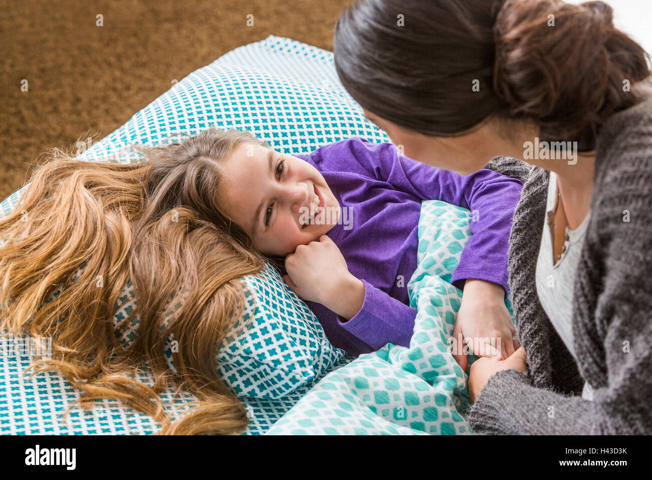 Mother comforting daughter at bedtime Stock Photo