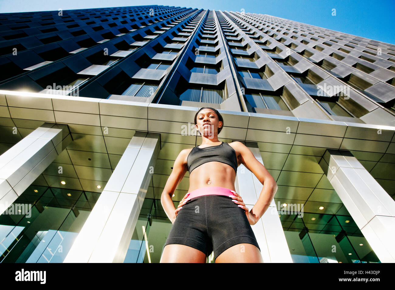 Serious Black woman standing under modern building Stock Photo