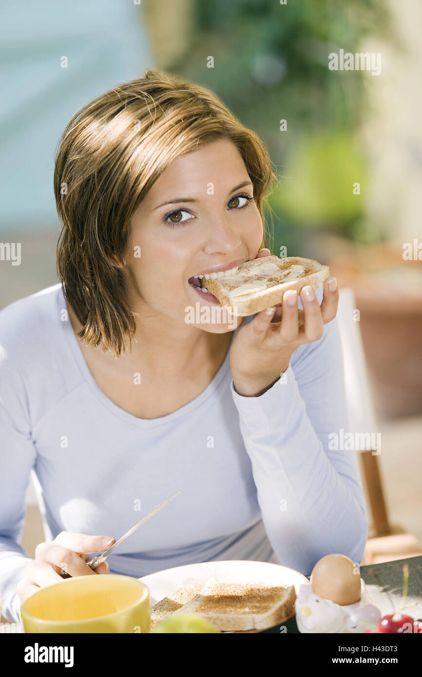 Woman, sit young, brunette, breakfast table, butter toast eat, model released, Stock Photo