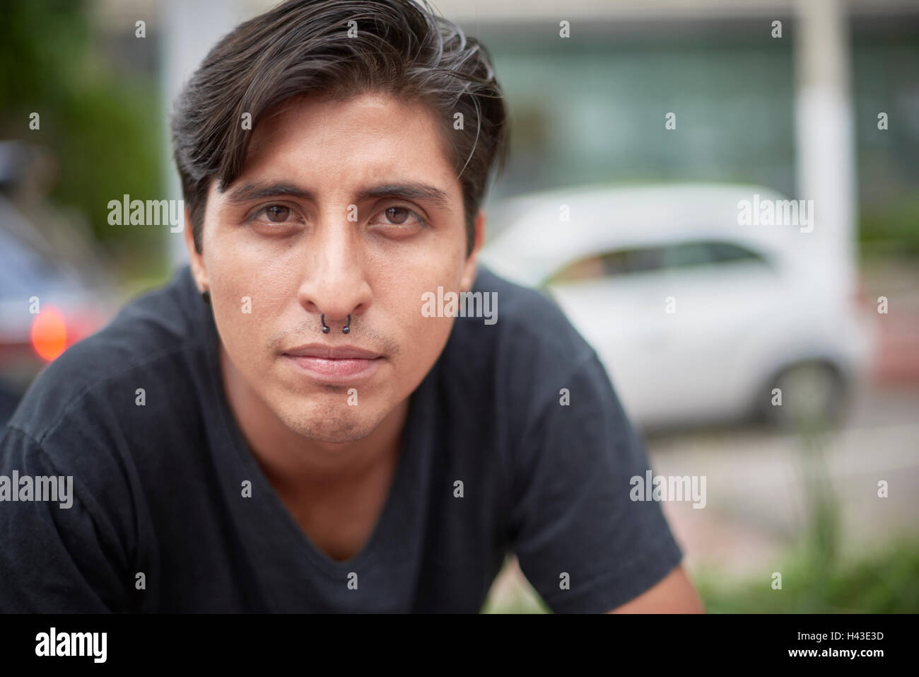 Serious Hispanic man with pierced nose Stock Photo