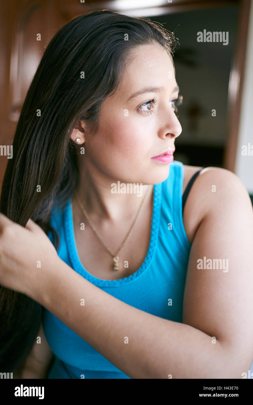 Hispanic woman brushing hair Stock Photo