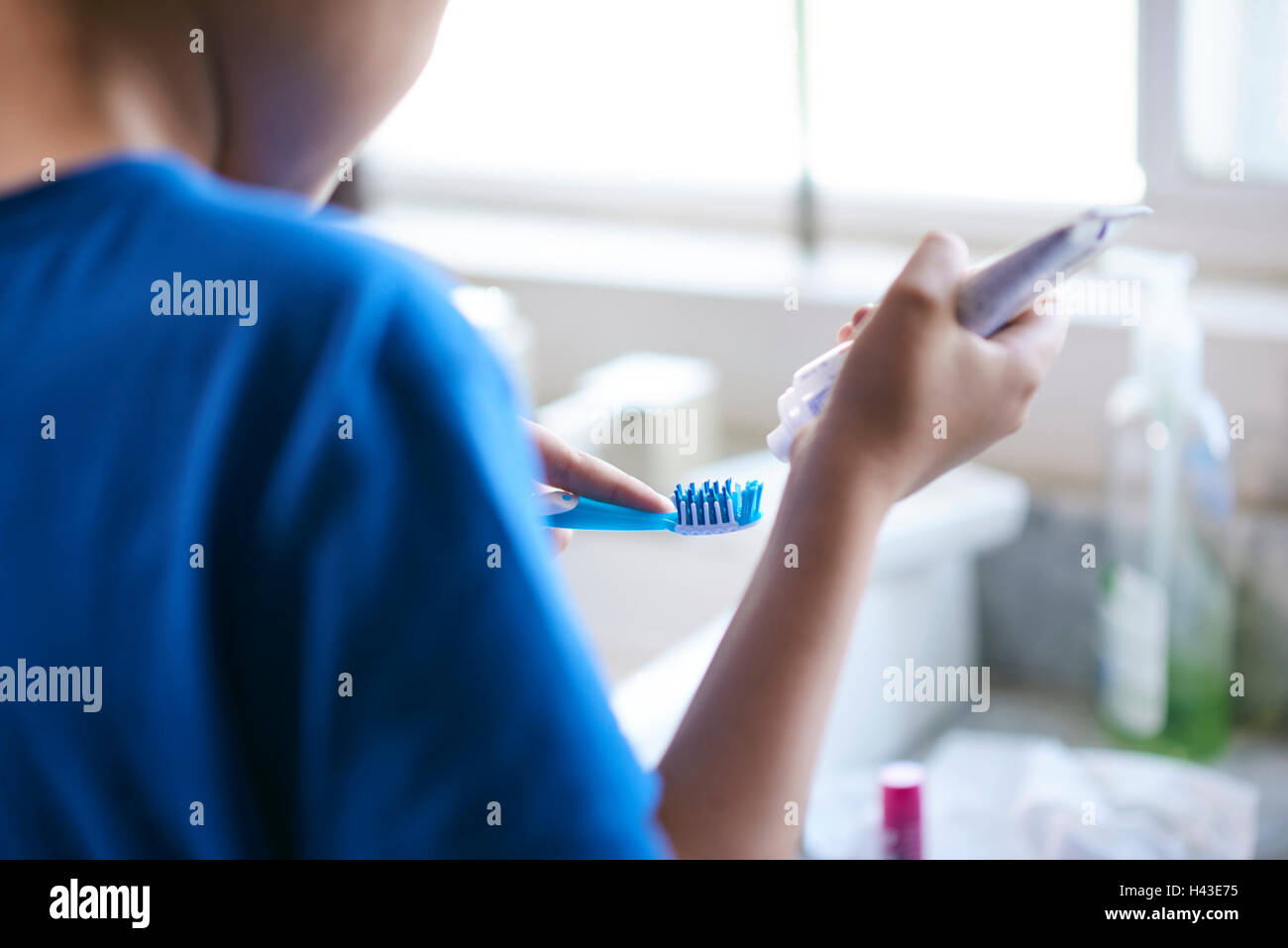 Hispanic by squeezing toothpaste onto toothbrush Stock Photo