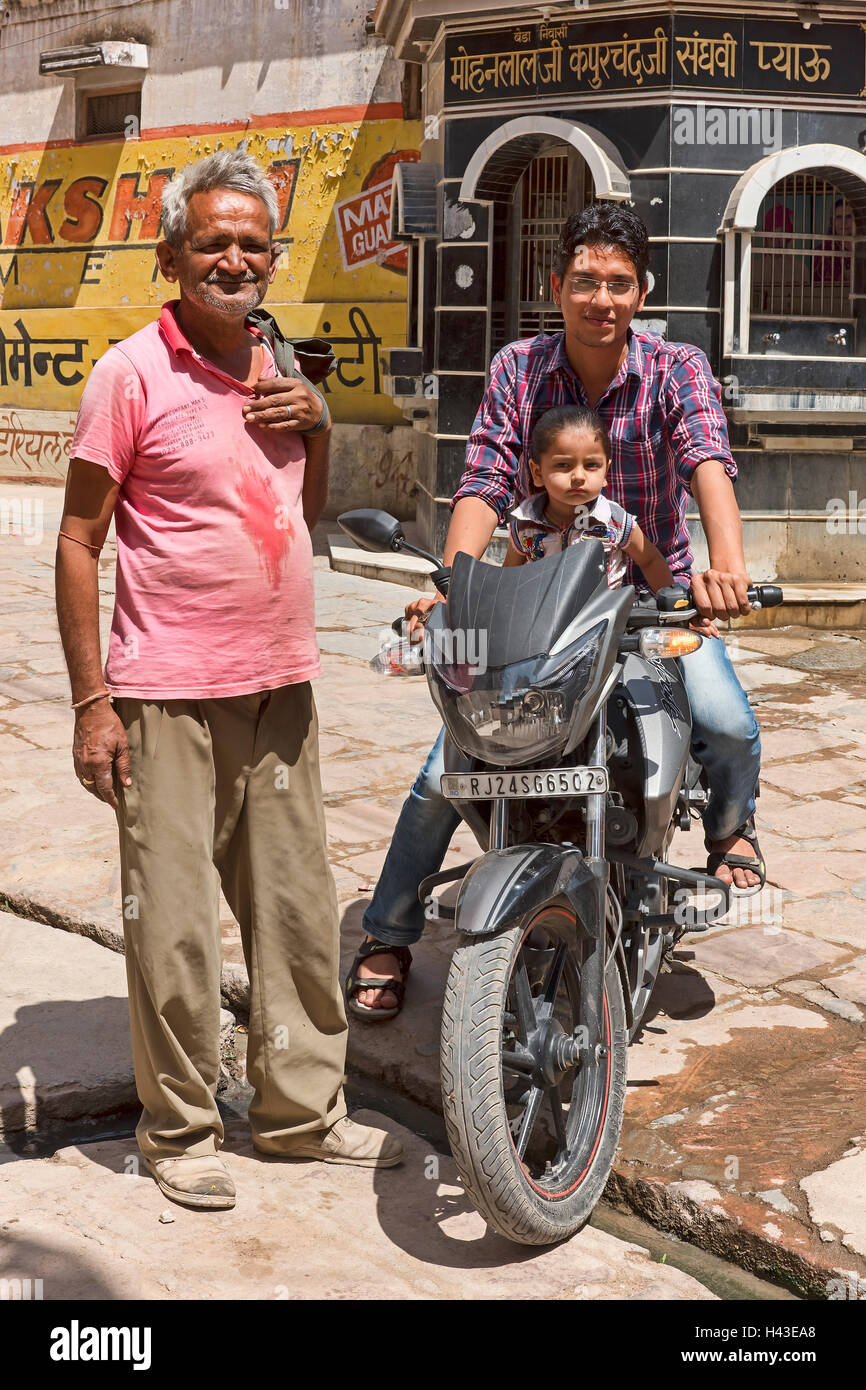 Man and child on motorcycle with older man, Bera, Rajasthan, India Stock Photo