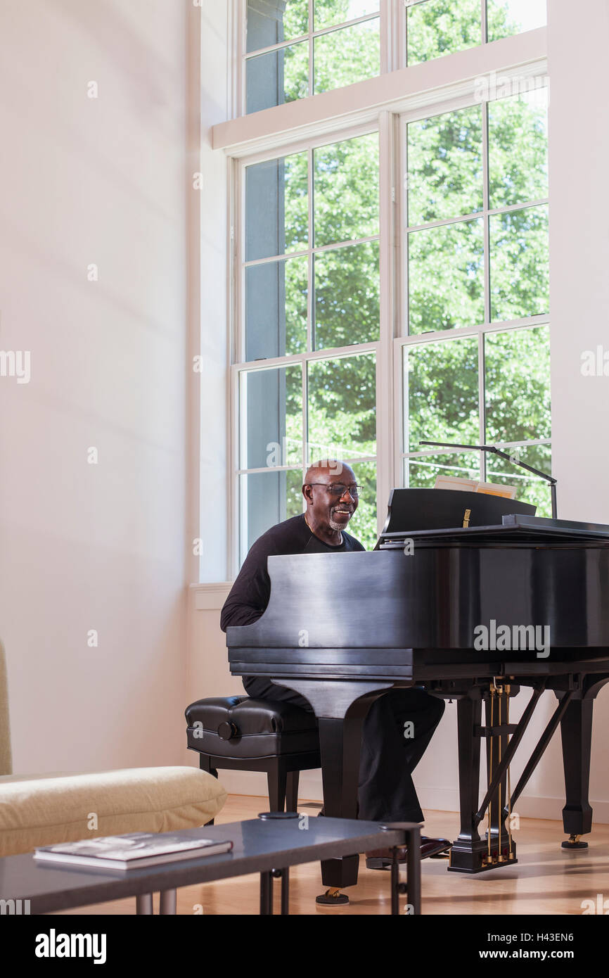 Man playing piano near window Stock Photo Alamy