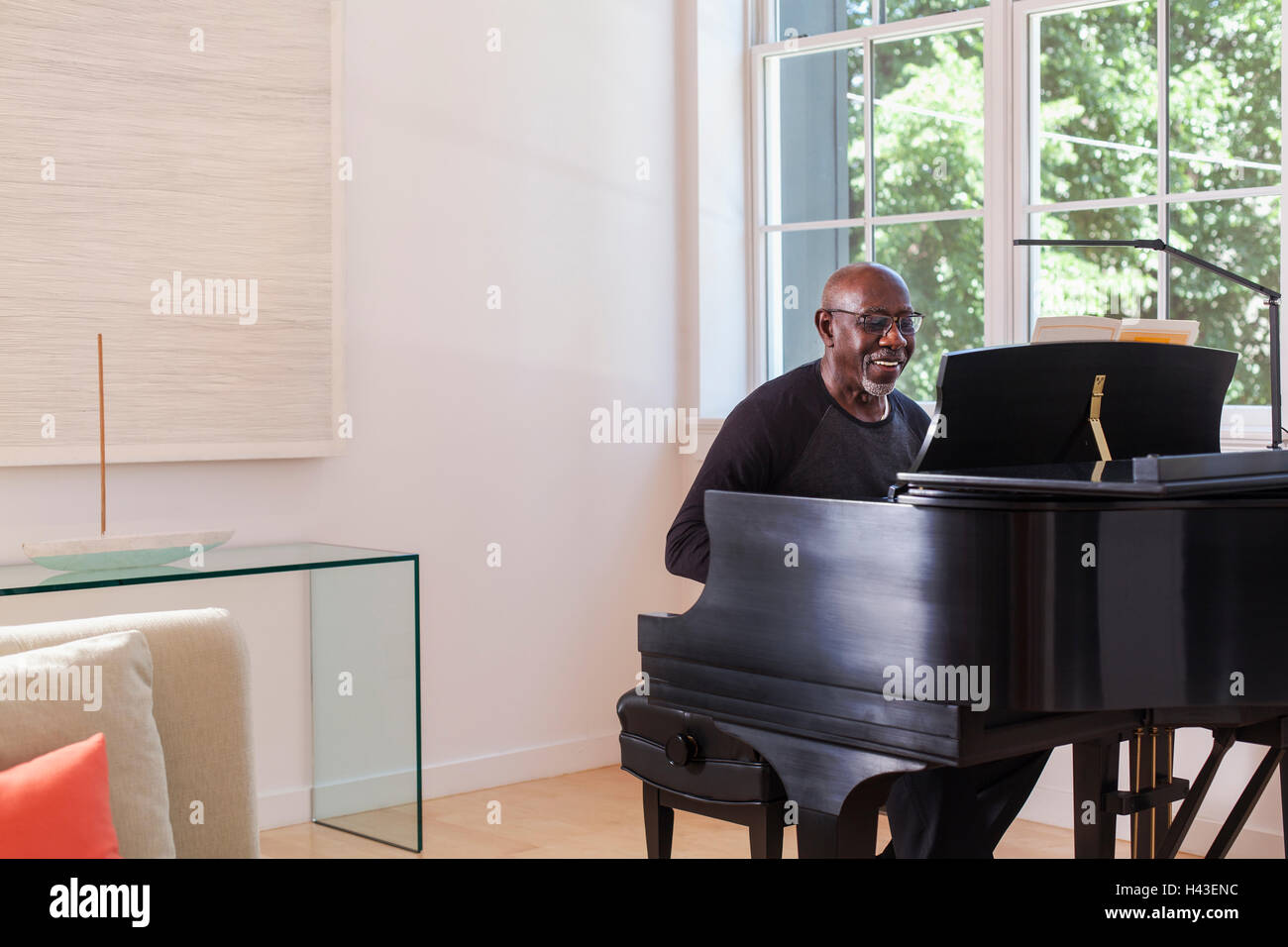 Man playing piano near window Stock Photo Alamy
