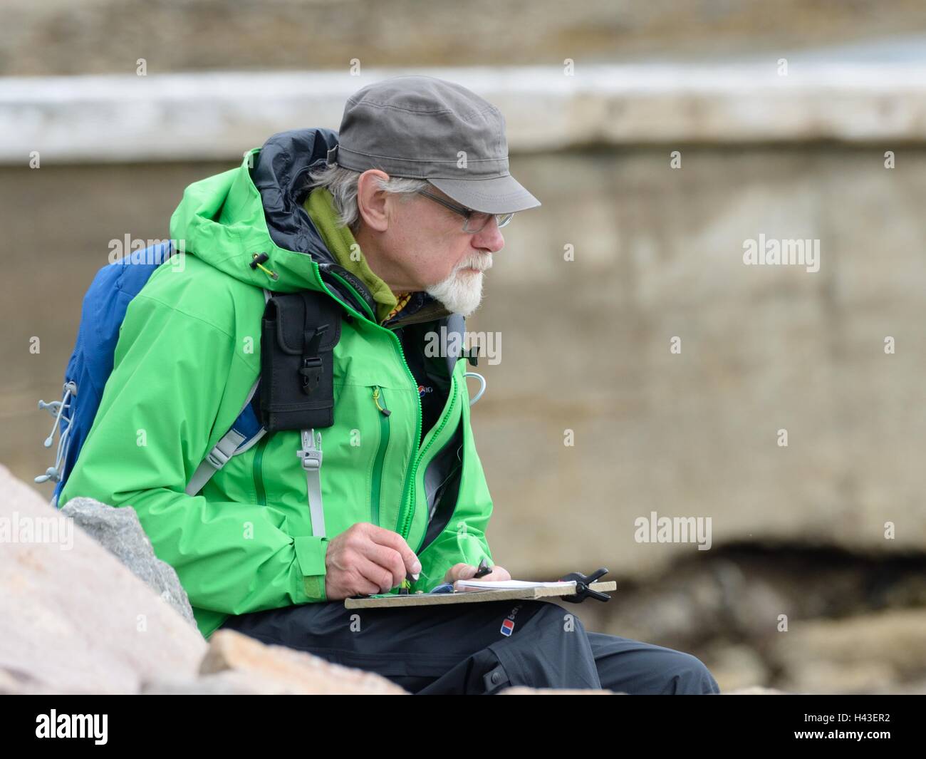 An artist (Kenneth MacLennan) sketching outdoors in the Ullapool, Scotland, UK. Stock Photo