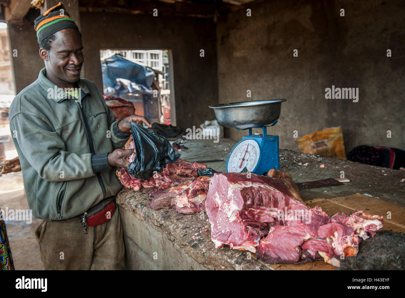 Butcher with meat at market, street scene, Bamenda, North-West Region, Cameroon Stock Photo