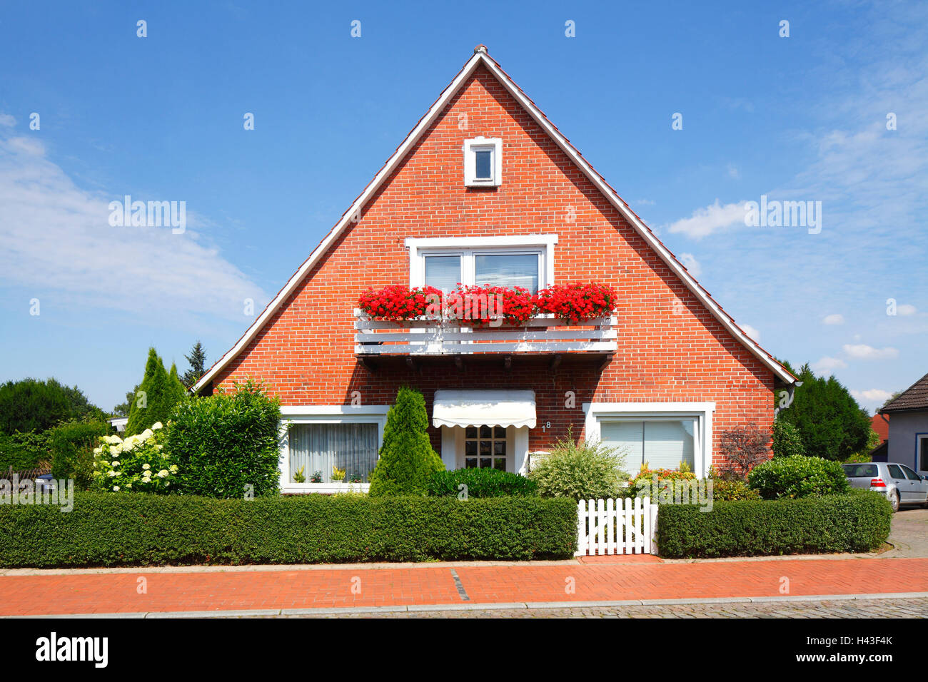 Brick house with geraniums on the balcony, Bruchhausen-Vilsen, Lower Saxony, Germany Stock Photo