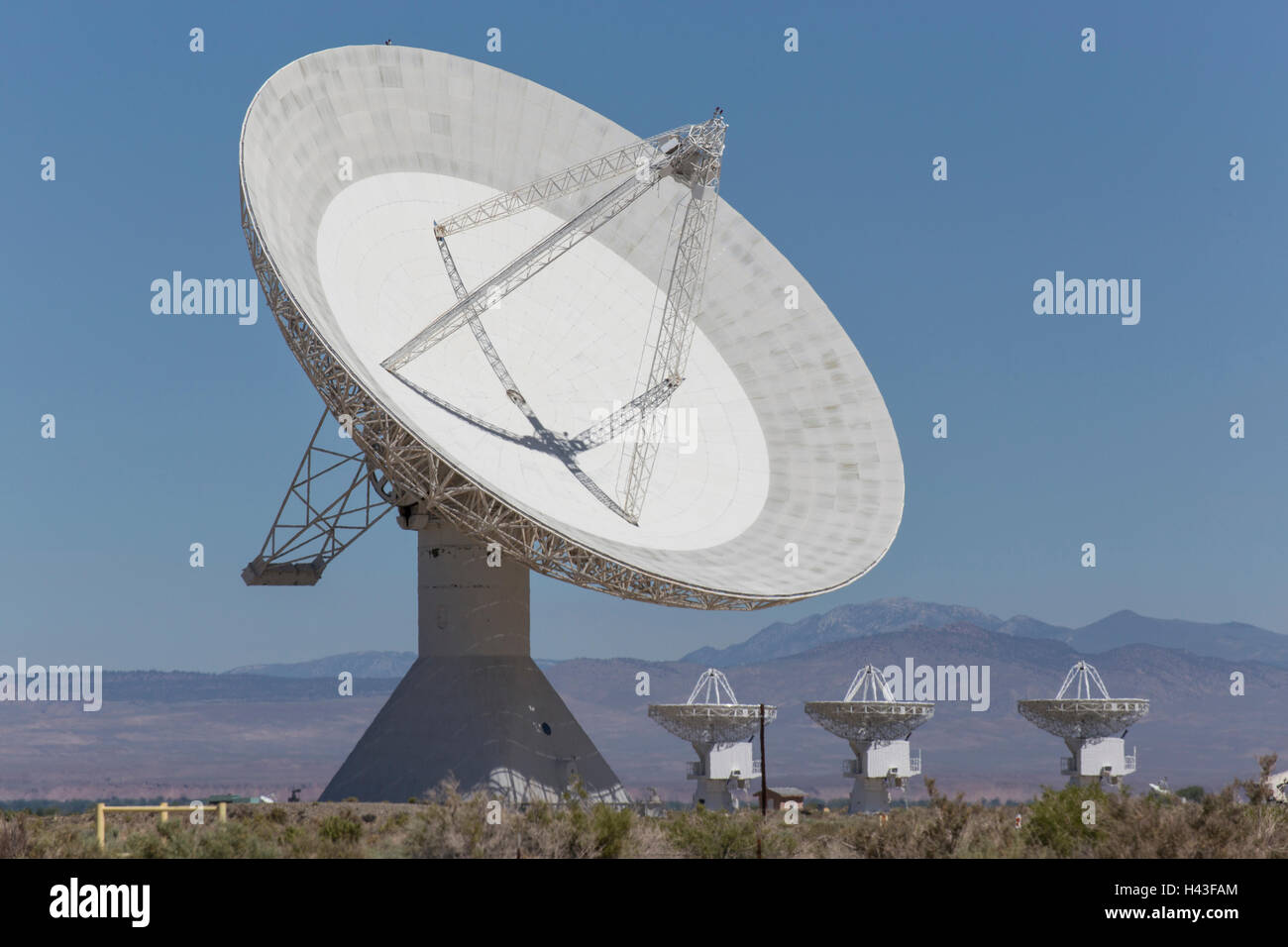 Satellite dishes in field near mountain range Stock Photo Alamy