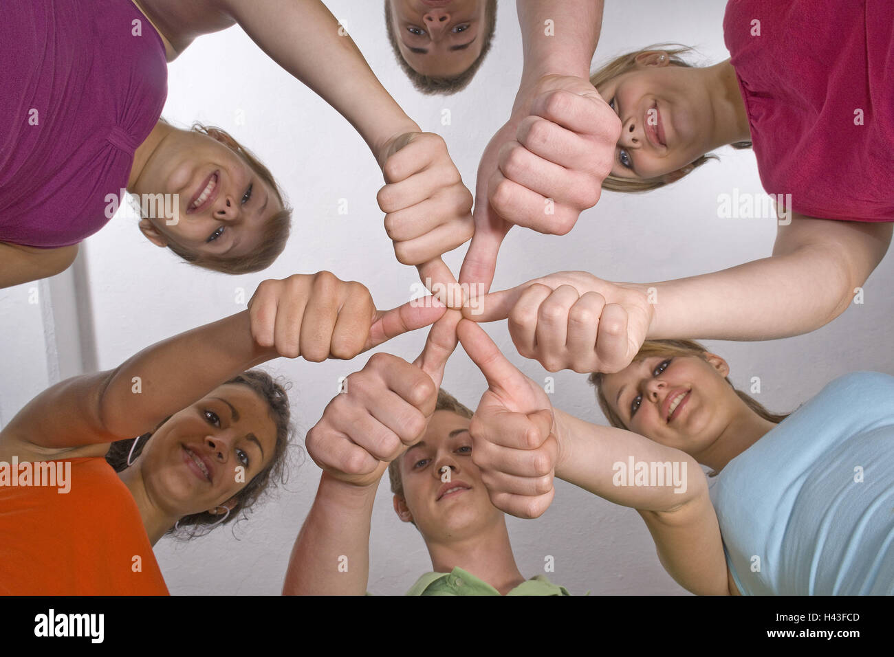 six young people, gesture, pollex each other, circle, view camera, from below, Stock Photo