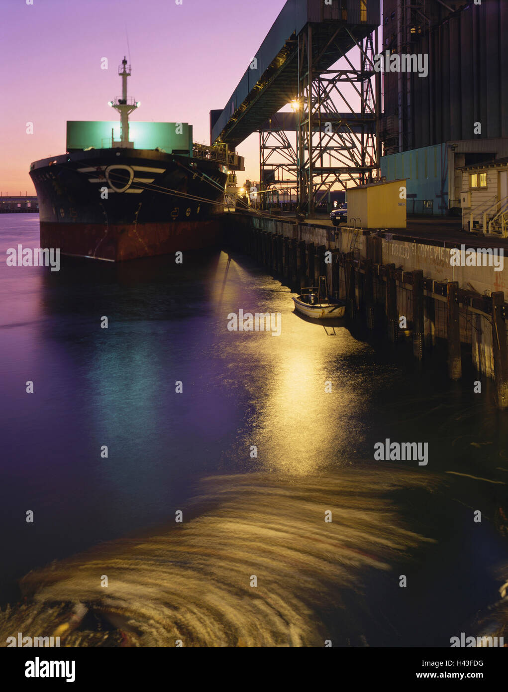Cargo ship in harbor at night Stock Photo