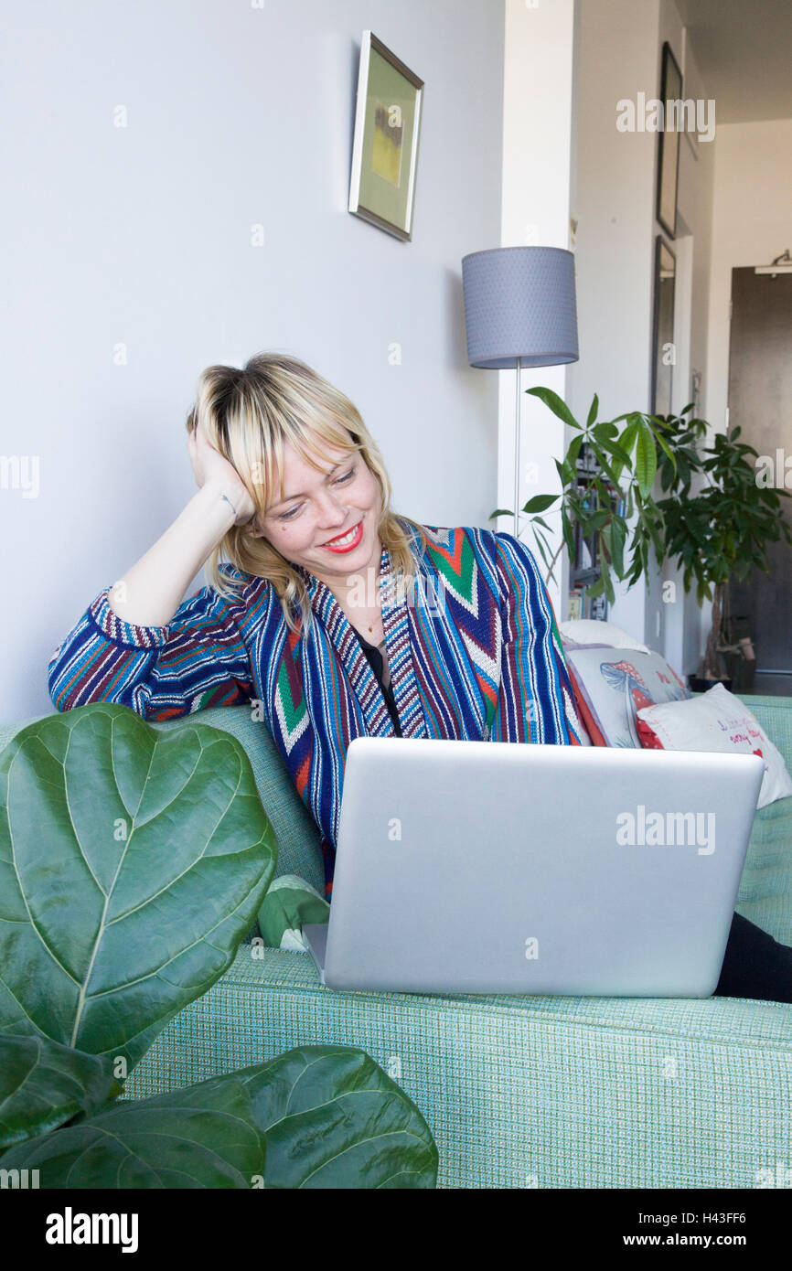 Laptop woman sitting on sofa hi-res stock photography and images - Alamy