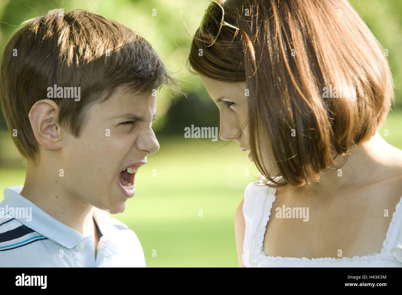 Siblings, eye contact, shout, portrait, side view, curled, teenager
