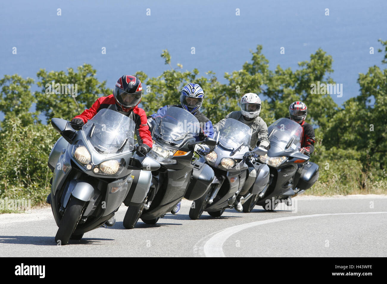 Tourer VT, group, country road, bend, 4th formation, scenery, motorcycle group, person, driver, motorcyclist, four, one after the other, together, motorcycles, motion, street, Tourer, go, front view, Stock Photo