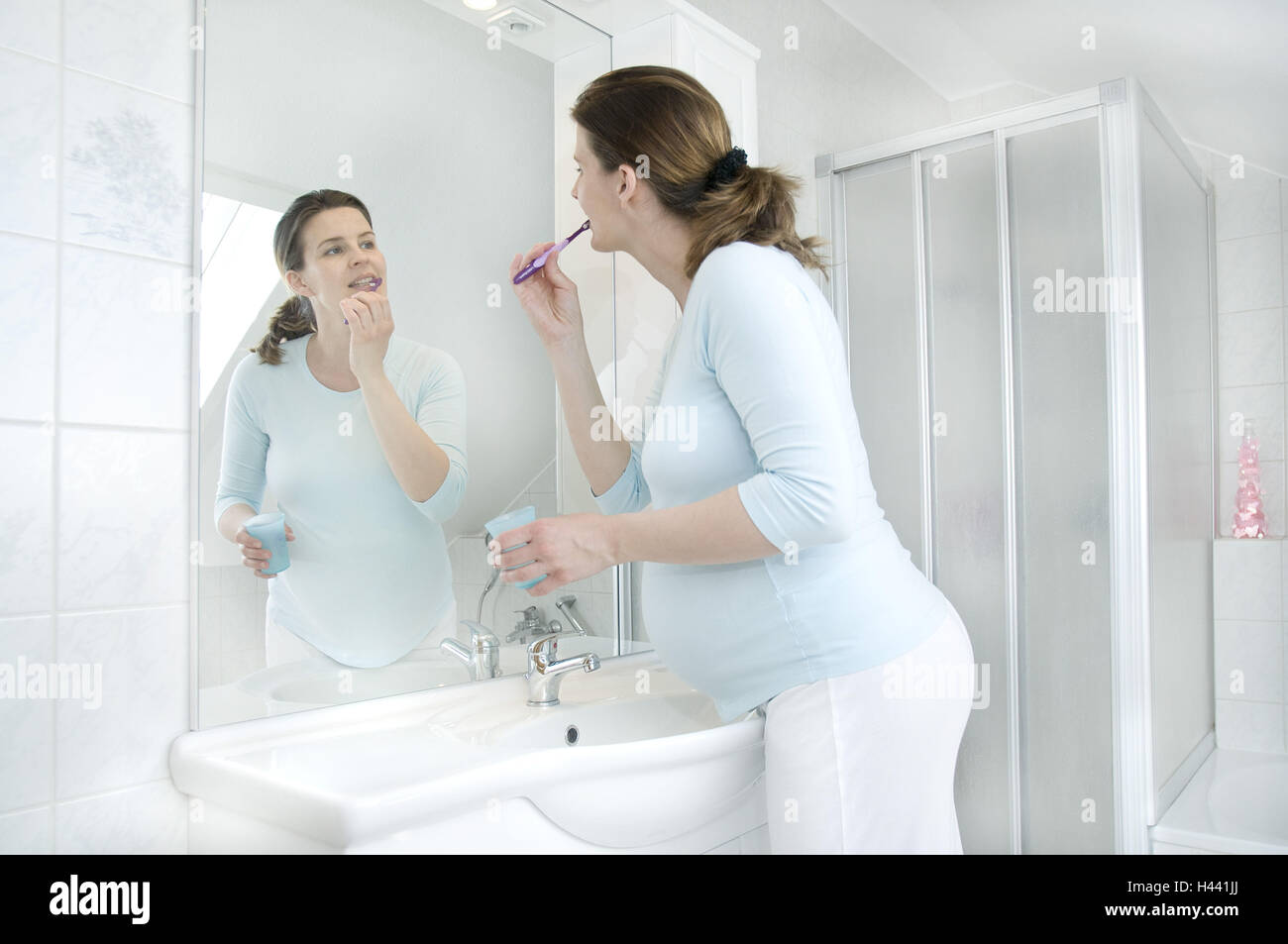 Woman, young, pregnant, bathrooms, stand, cog cleaning, reflexion, model released Stock Photo