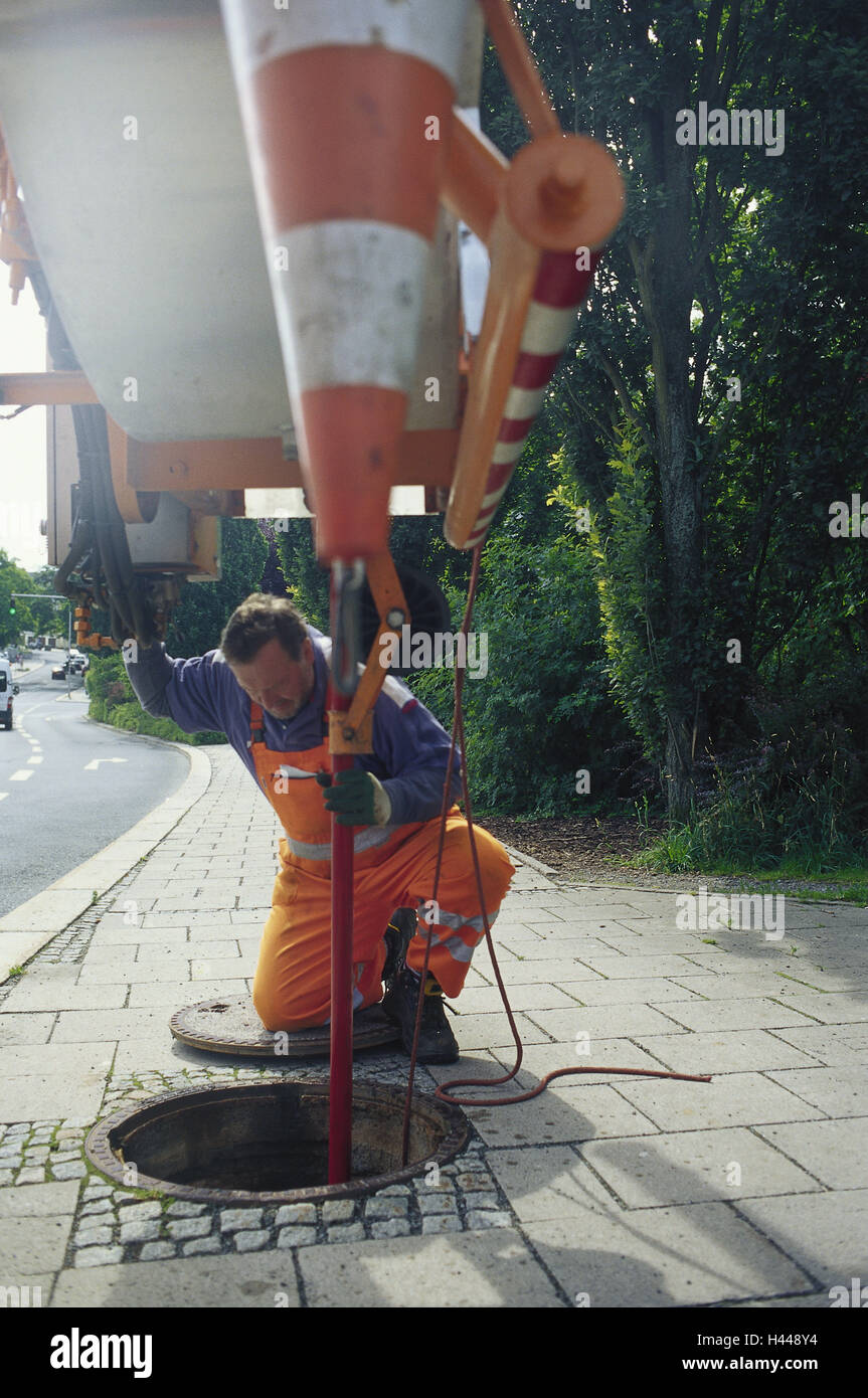 Parish workers, cleaning, sewer, orifice, flexible tubing, no model release, person, man, work, occupation, town worker, overalls, orange, vehicle, pressure hose, suction cleaning, pump out, clean, drain, bedding-in bay, kneel, Stock Photo