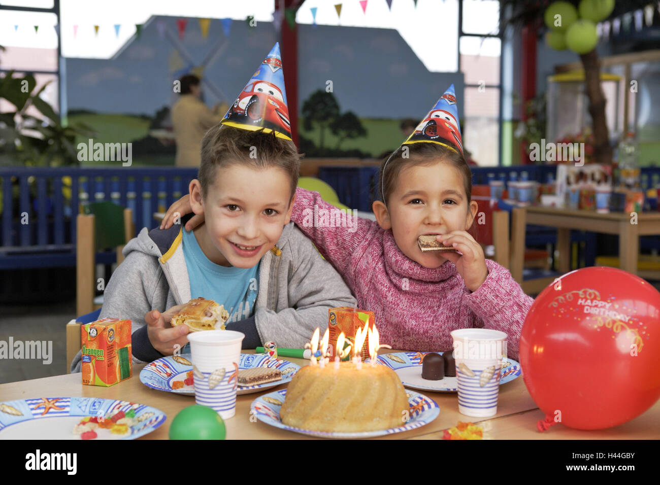 Children's birthday party, boy, girl, paper hats, cakes, eat, people, children, siblings, birthday cakes, party, birthday party, celebrate, amusements, happy, party caps, headgear, fun, joy, lighthearted, candles, burn, birthday, Stock Photo