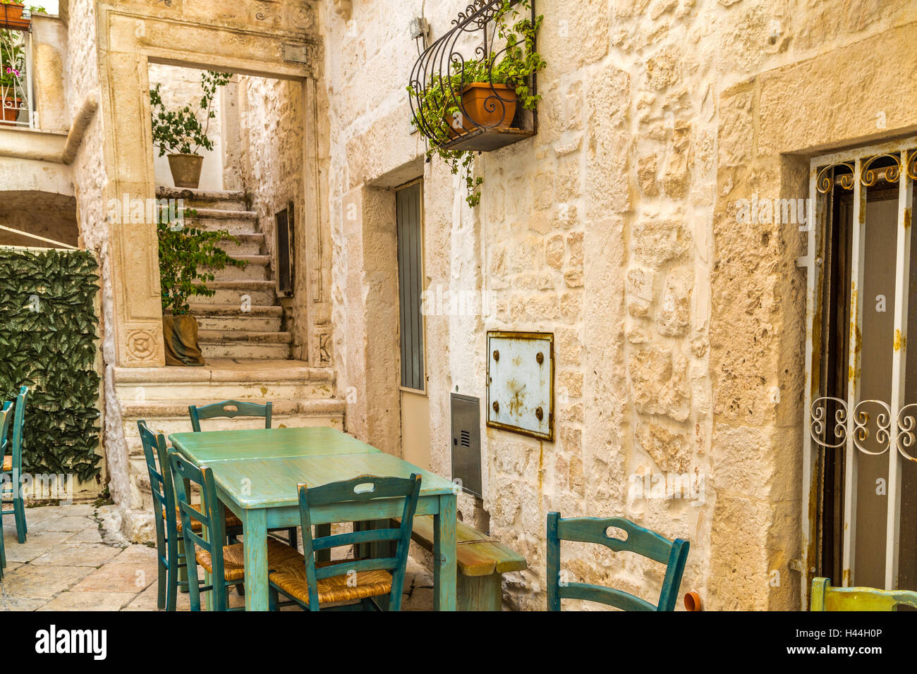 typical Italian street with table and chairs in small village in Apulia Stock Photo