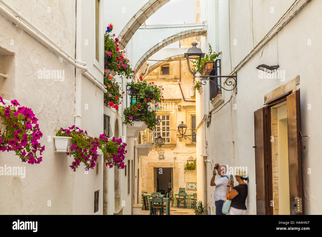 Locorotondo, Apulia, Italy,  tourists taking photos of whitewashed houses with flowers Stock Photo