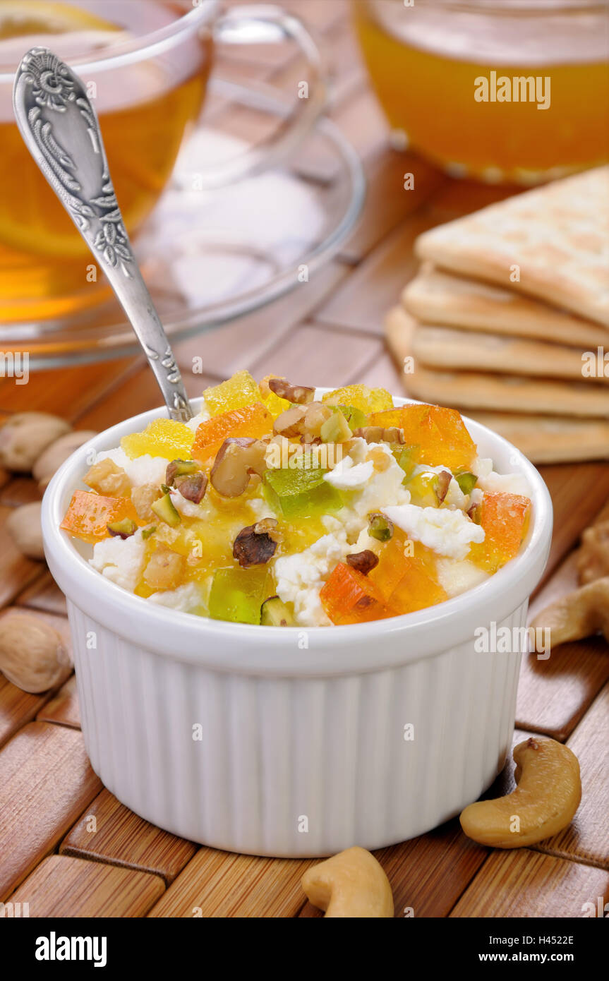 portion of cottage cheese with jam and marmalade slices, nuts, pistachios Stock Photo