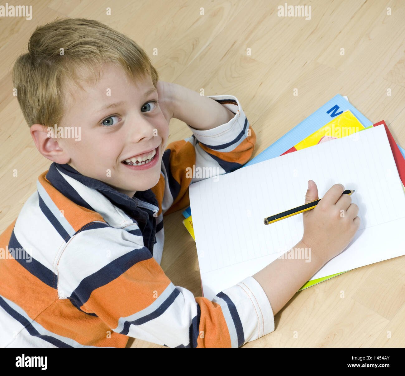 Boy, floor, lie, add support head, homework, writes, block, portrait, Stock Photo