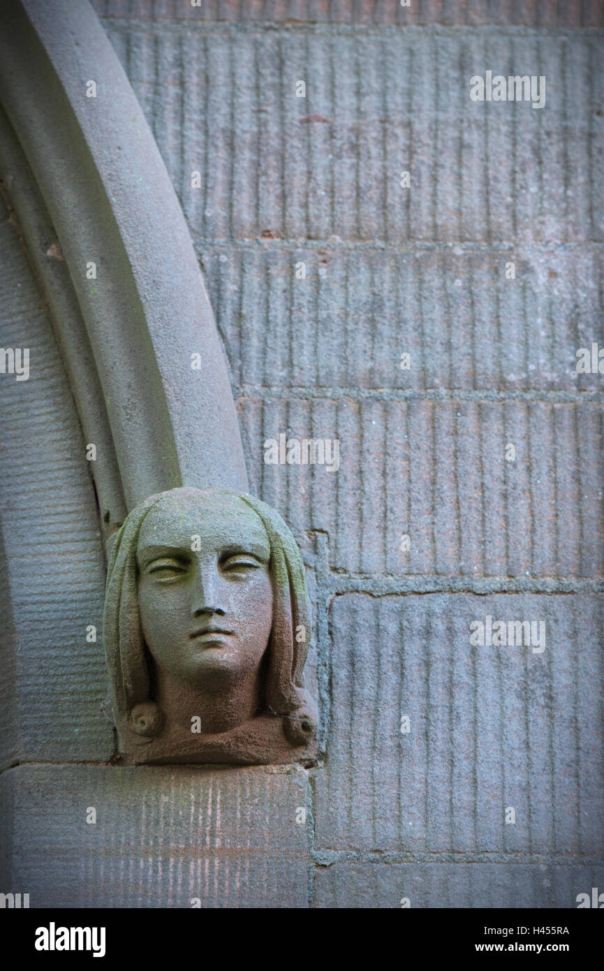 Stone face on a church window surround with open eyes. Wasperton, Warwickshire, England Stock Photo