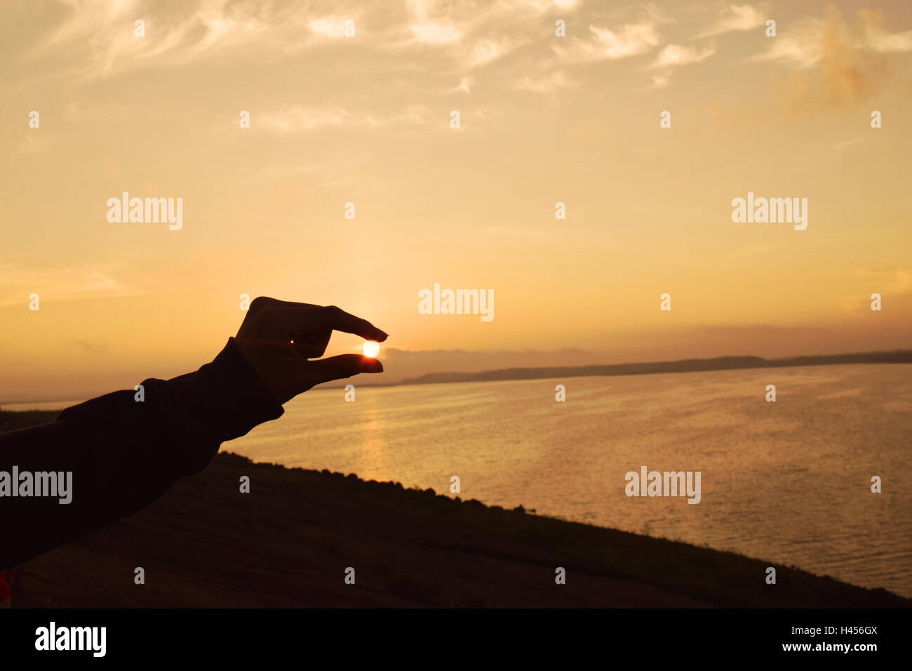 silhouette hand capture the sun in sunset Stock Photo - Alamy