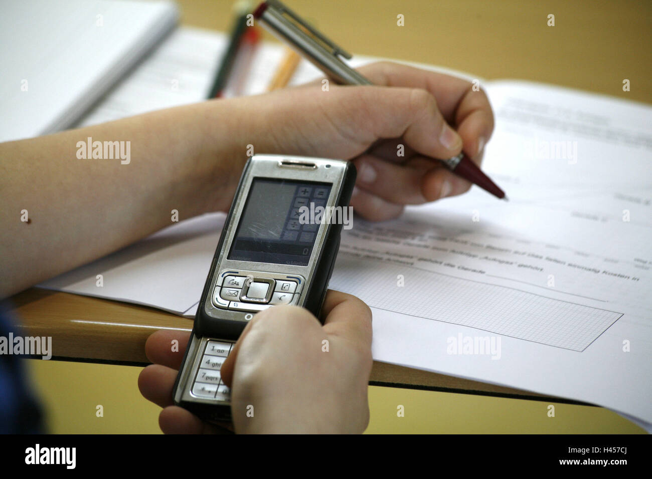 Schoolboy, school work, mobile phone, electronic calculator, medium close-up, detail, Stock Photo