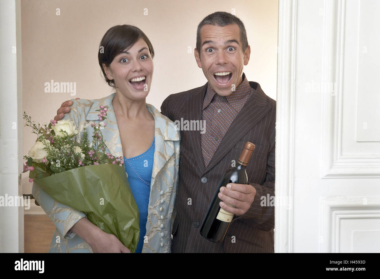 Pair, laughs, flower bouquet, wine bottle,  Doorframes, stands, Halbporträt,   20-30 years, door, laughs party flowers, wine, joy, surprise, New Year's Eve, birthday friends apartment moves happily, Lifestyle, partnership, weekend, couple, invitation, meal, party, inauguration, guests, gift, fun, visit, invitation, coated, strange, leisure time, surprise visit, Stock Photo