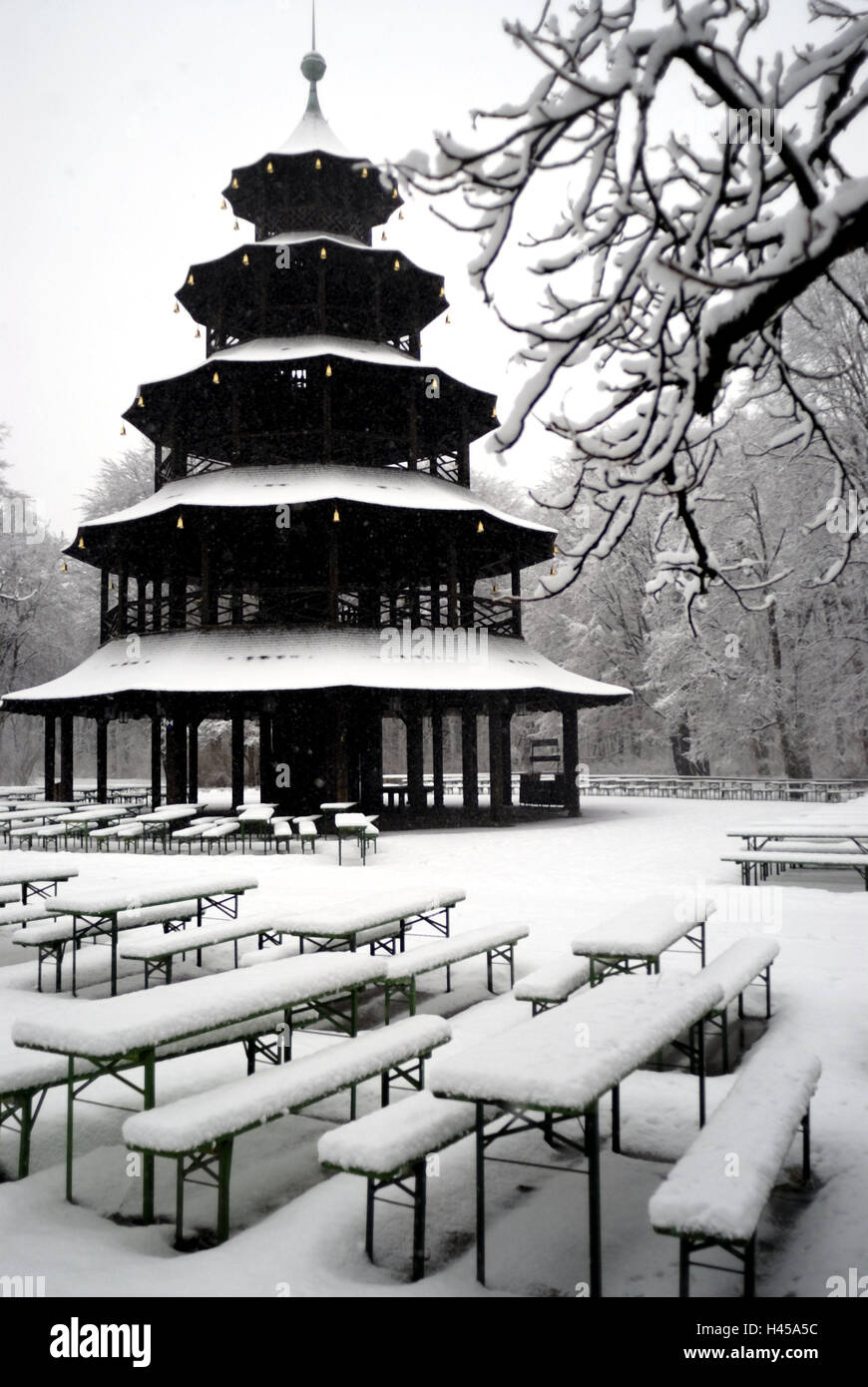 Germany, Munich, English garden, Chinese tower, beer garden, winter, Bavaria, Upper Bavaria, Schwabing, scenery park, scenery garden, town park, local recreational area, park, building, pagoda, gastronomy, uncolored, trees, broad-leaved trees, garden architecture, beer tables, beer benches, tables, benches, snow-covered, seat opportunities, nobody, deserted, snow, winter scenery, dreary, season, silence, loneliness, colour mood black-and-white, Stock Photo