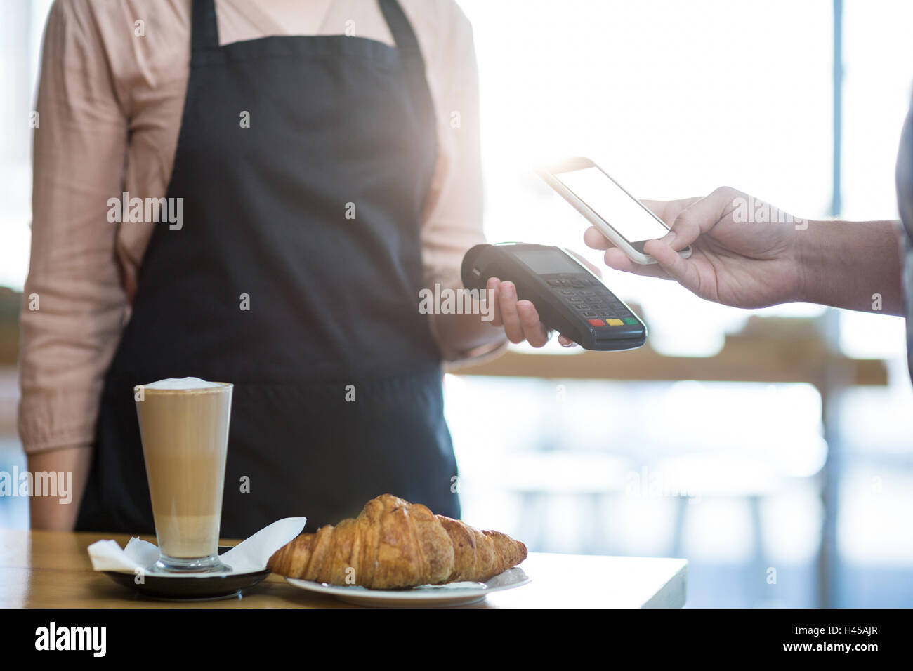 Man paying bill through smartphone using NFC technology Stock Photo - Alamy