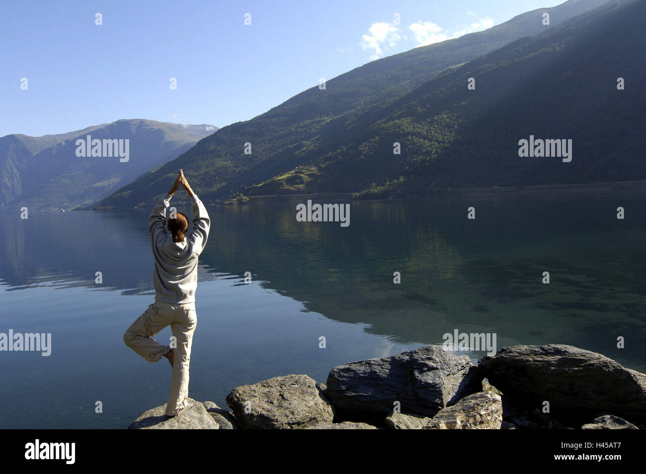Norway, mountain lake, rock-coast, woman, yoga practice, gets along back view, series fjord-country Aurlandsfjord people meditation, Yoga, practice, 'the tree', relaxation, recuperation, concentration, harmony, relaxation, balance, stress-reduction, health, well-being, body-feeling, unison, Lifestyle, outside, leisure time, balance, silence, energy, energy-river, Yogaposition, balance, balance, full-length, barefoot, Stock Photo