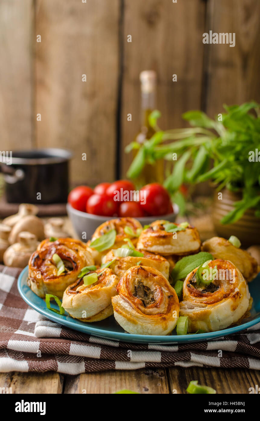 Pizza snails in puff pastry with ham, cheese and mushrooms Stock Photo