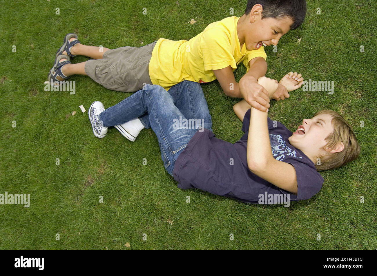 Boys, two, turfs, lie, scuffle, model released, people, children, friends, outside, meadow, park