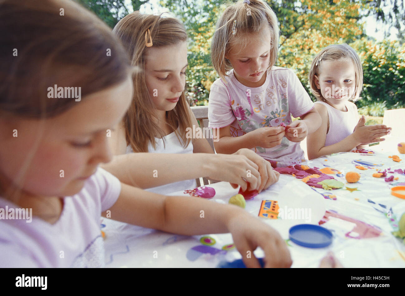 Girls, smile, do handicraft, plasticine, terrace table, person, children, siblings, friends, together, leisure time, creativity, knead, group work, support, learn, play, fun, summer, outside, concentrates, terrace, four, activity, leisure activity, Stock Photo