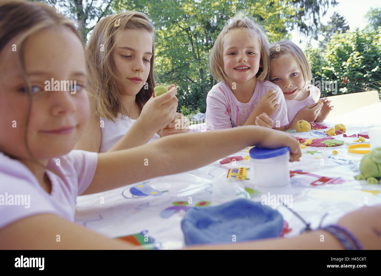 Girls, smile, do handicraft, plasticine, terrace table, person, children, siblings, friends, together, leisure time, creativity, knead, group work, support, learn, play, fun, summer, outside, concentrates, terrace, four, activity, leisure activity, Stock Photo