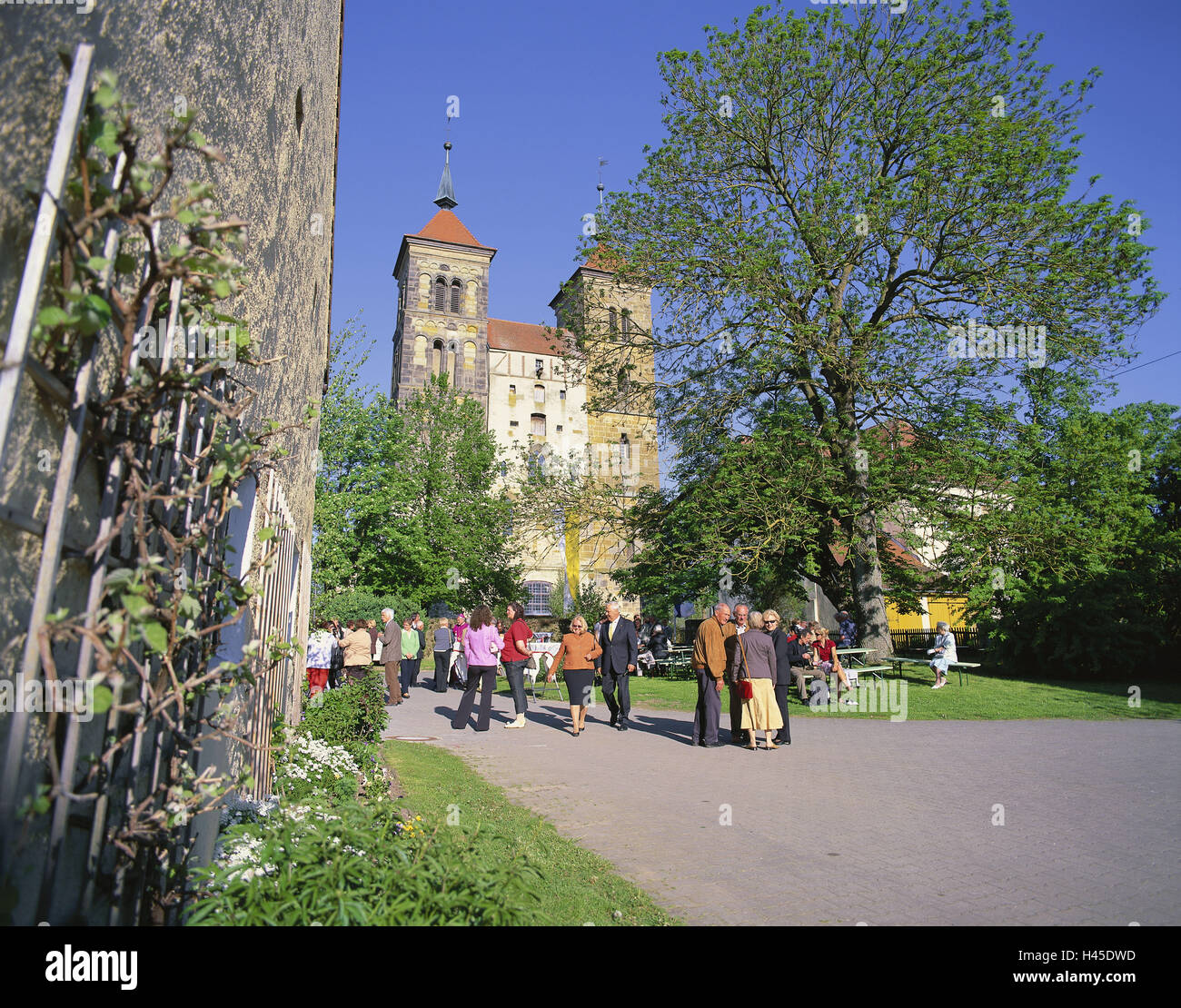 Germany, Bavaria, Auhausen, minster, Swabian, city centre, basilica, towers, doubles tower, west facade, person, outside, turfs, way, trees, defensive wall, tourist, visitor, place of interest, architecture, faith, religion, Christianity, church, sacred construction, Stock Photo