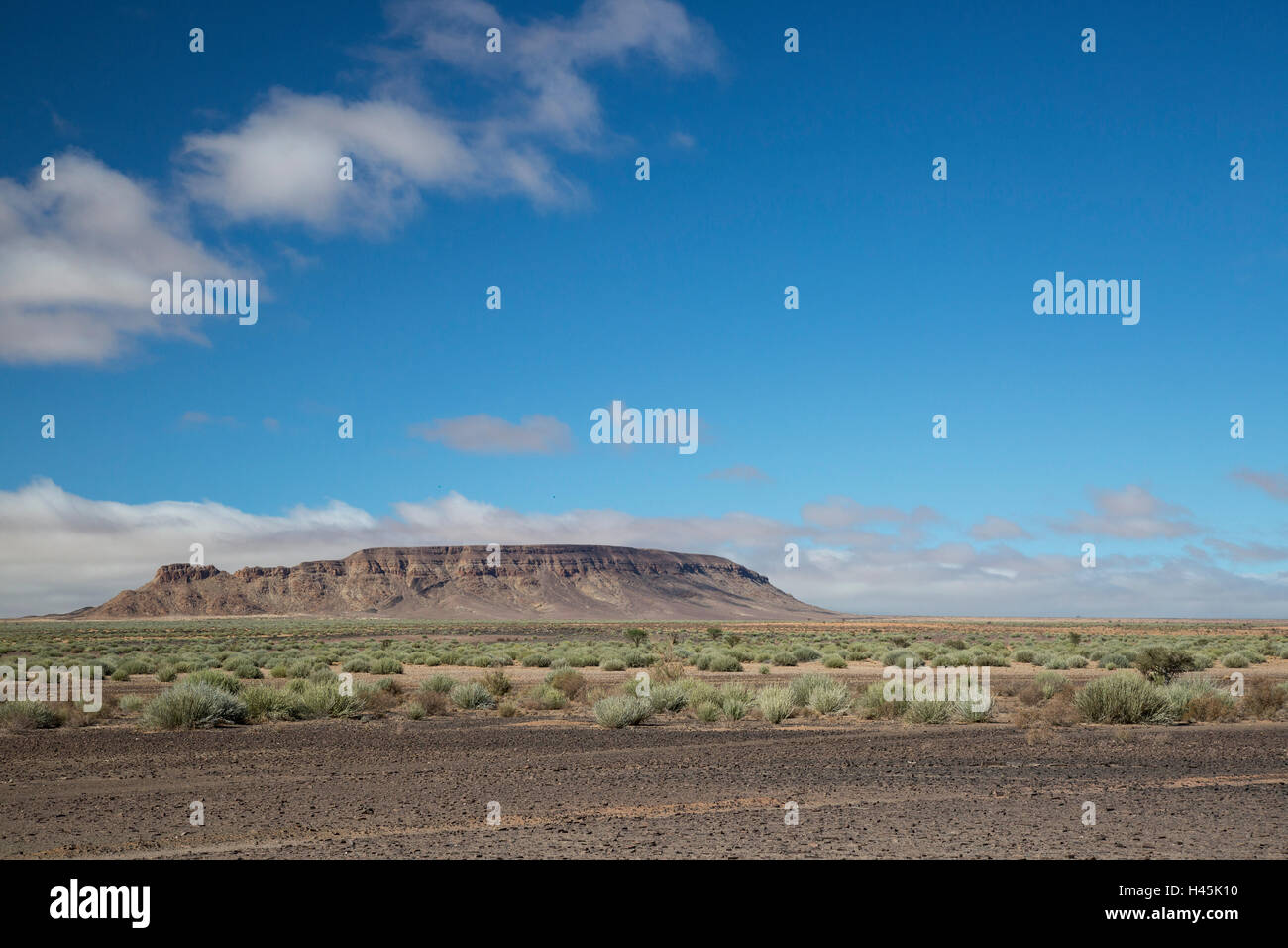 Arid landscape with a flat-topped mountain in the distance Stock Photo