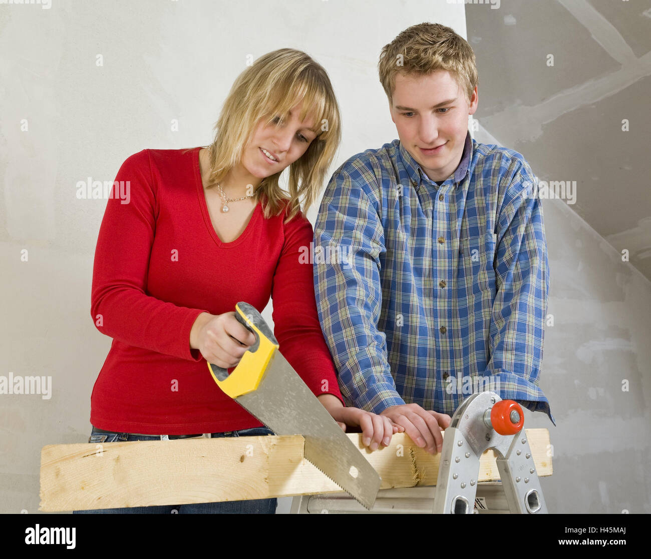 Couple, young, saw, wooden beams, saw off, teamwork, icon, do it yourself, half portrait, person, construction, men at work, build, attic, attic, upgrading, roof upgrading, DIY, do-it-yourselfer, tools, wooden, beam, hold, saw, together, team, Stock Photo