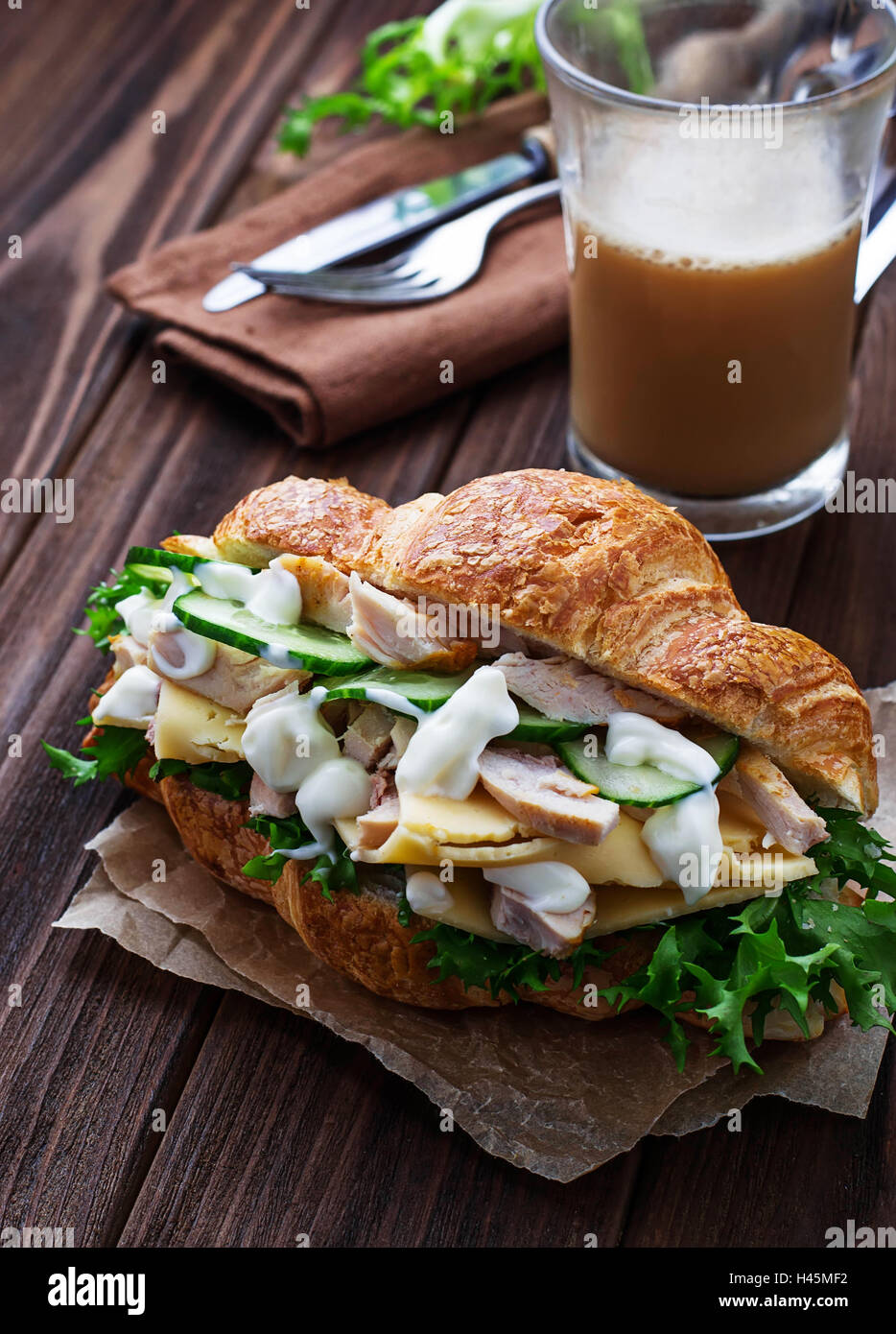 Croissant sandwich with chicken, cheese, cucumber. Selective focus Stock Photo