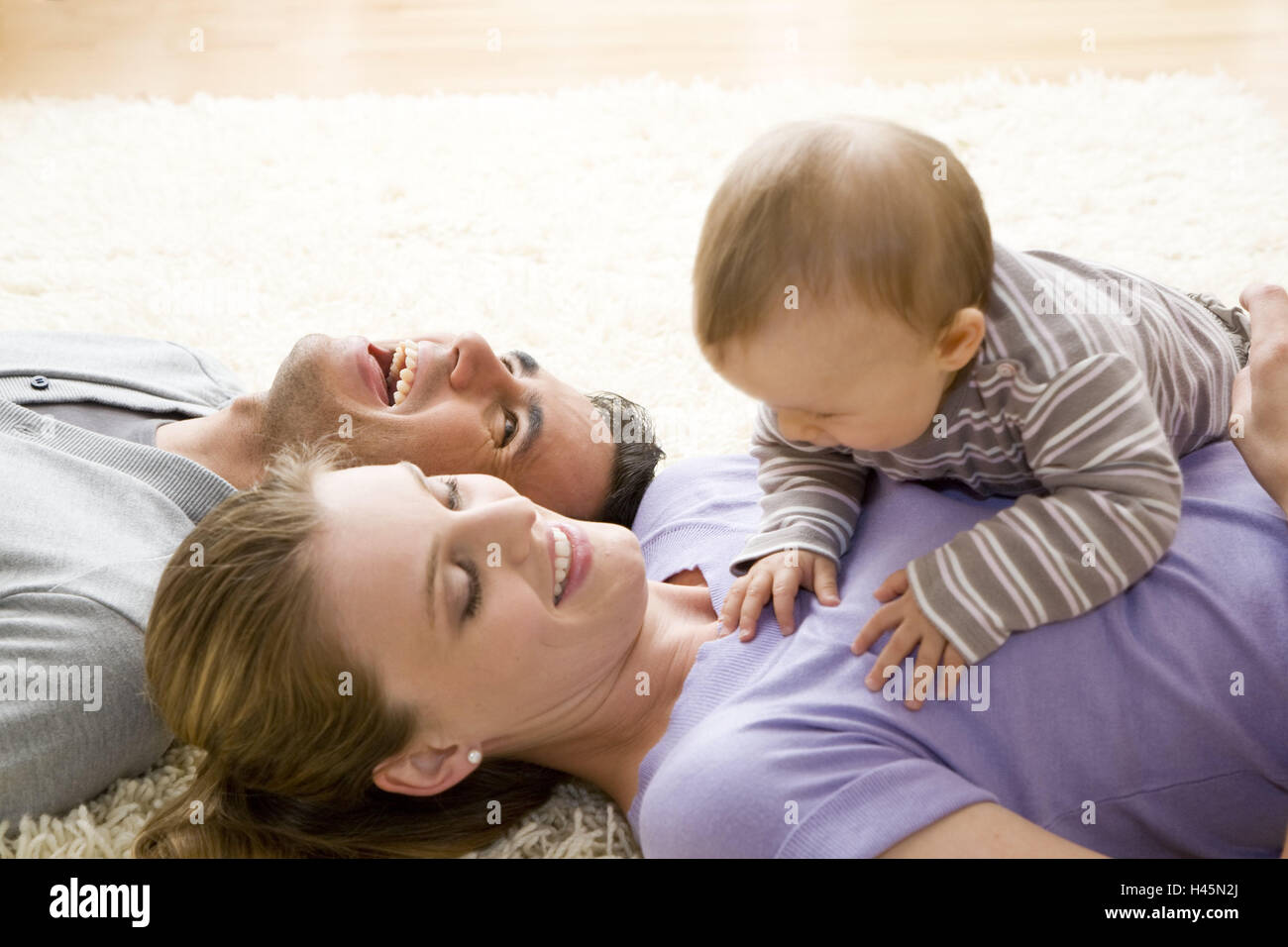 Couple, baby, floor, lie, play carpet, happy, trust, icon, looks, together, partnership, love, affection, cohesion, infant, family luck, pride, paternal love, motherly love, care, harmony, person, child, inside, family, parents, happy, floor, look, Stock Photo