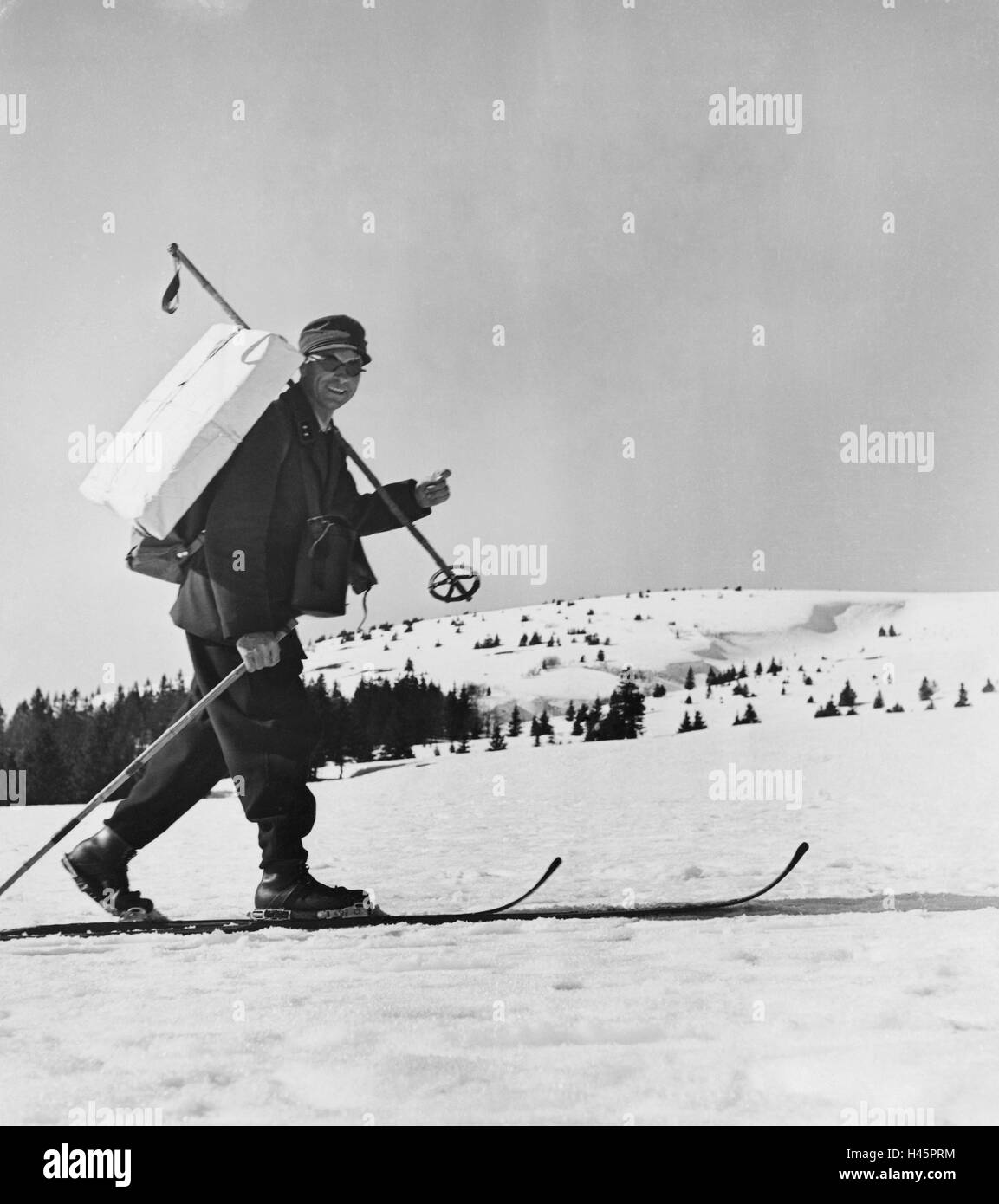 Germany, postman, skis, packet, merry, winter landscape, human, man, postman, go, carry, positive, ski equipment, post office, postal service, delivery, delivery, package delivery, parcel delivery, Skiing, Cross-country skiing, historical, nostalgia, seas Stock Photo