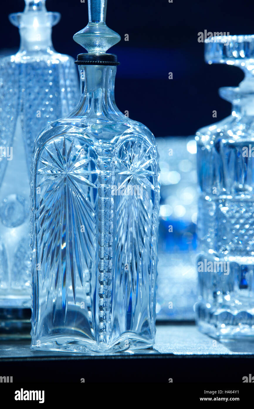 Empty crystal bottles for liquor in blue tone. Vertical Stock Photo