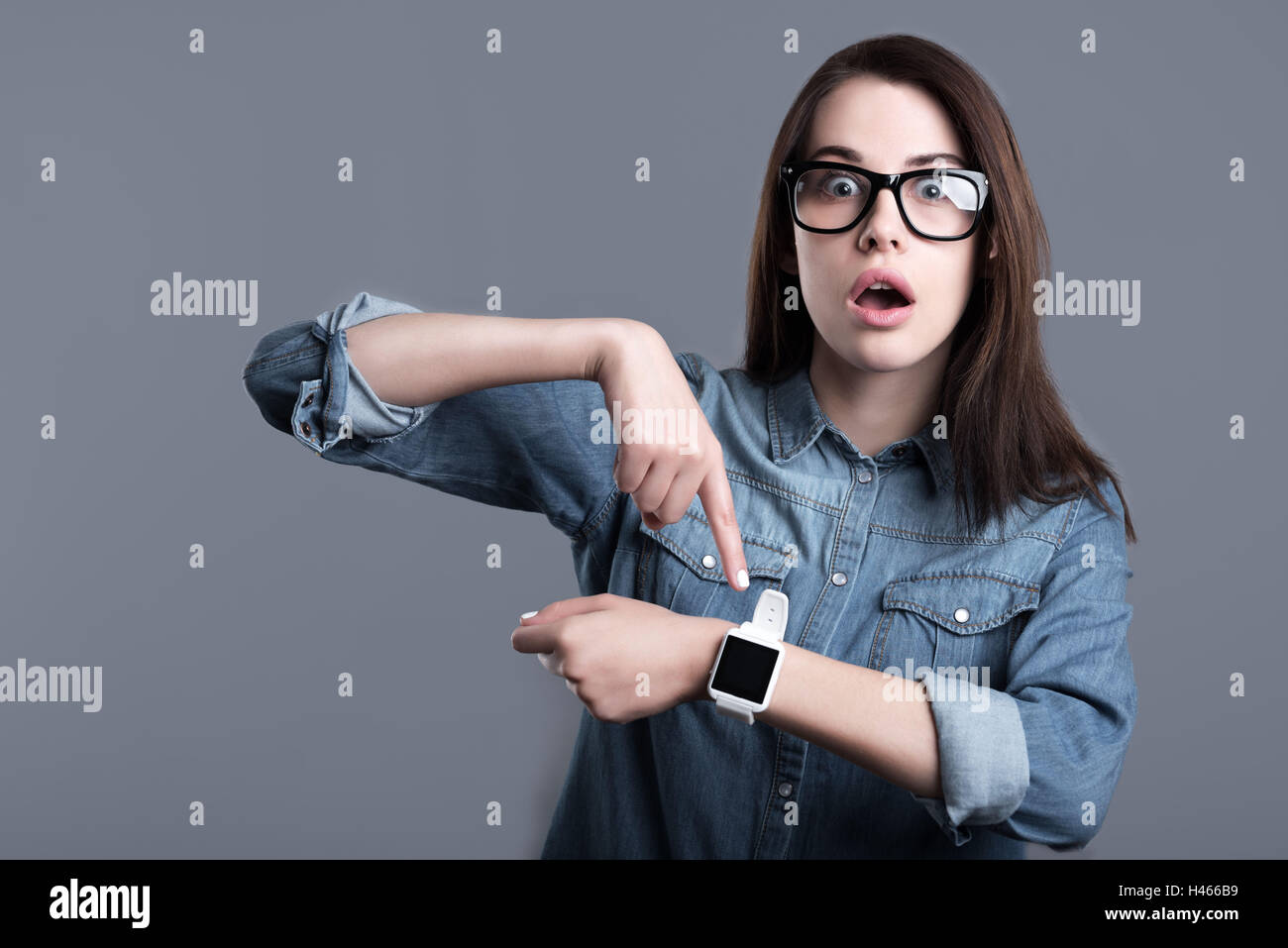 Surprised young woman wearing smartwatch Stock Photo